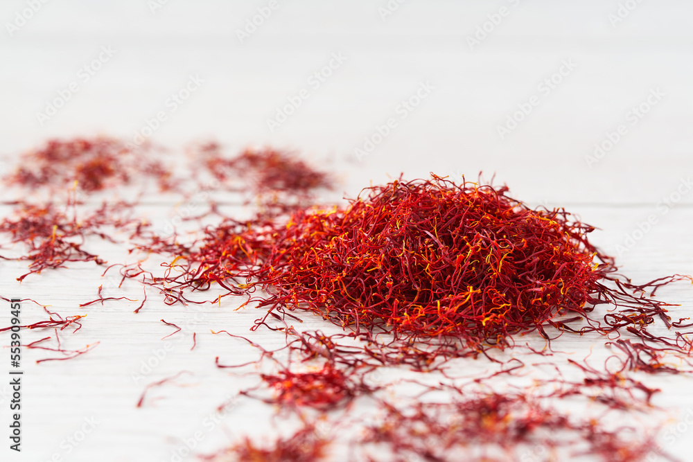 Naklejka premium Dried saffron spices on a wooden table, selective focus.