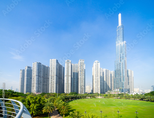 Morning view with sunny and green trees at Landmark 81 - it is a super tall skyscraper with development buildings along Saigon river in Ho Chi Minh city, Vietnam. photo