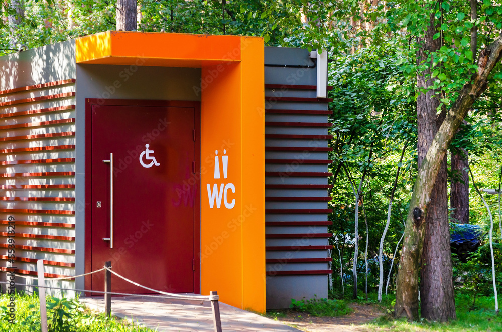 Modern public toilet in city park. Toilet with icons disabled person