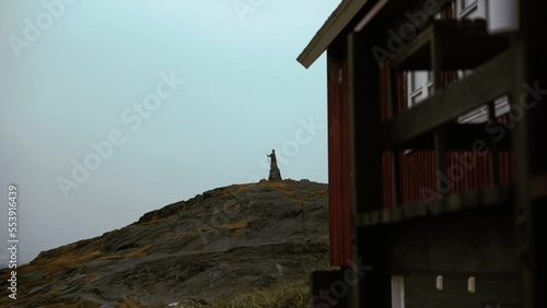 Hans Egede statue. Nuuk city in foggy daylight wide shot, pan right photo