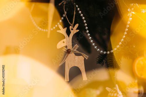 Wallpaper Mural Christmas tree with festive lights, decorated with a piece of dried orange and wooden figurines, close-up. Torontodigital.ca