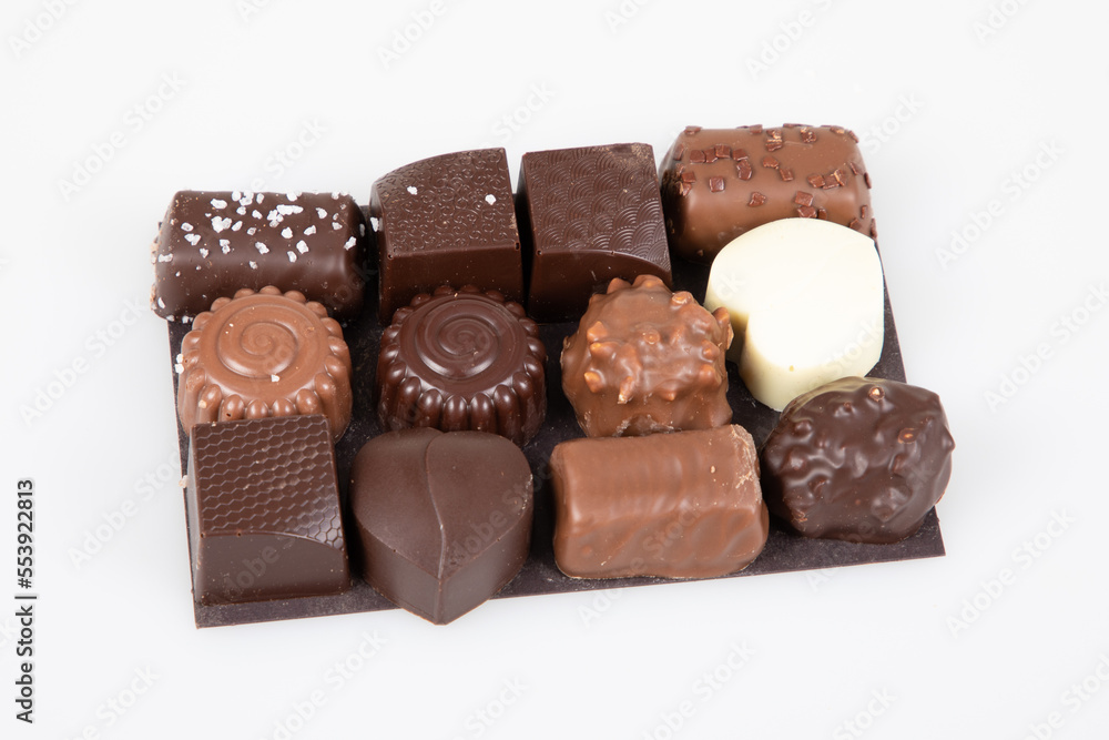 mix fine dark and milk chocolate in different shapes on presentation cardboard top view in white background mix fine dark and milk chocolate in different shapes on presentation cardboard top view in white background