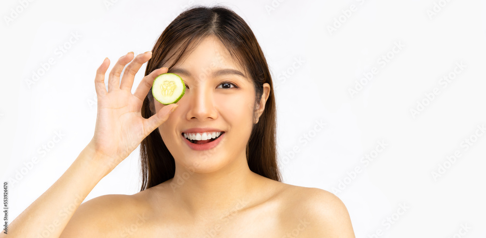 Young beautiful asian woman long hairstyle clean face skin smiling and holding cucumber on eye and looking camera white background, skin care beauty and spa. Young beautiful asian woman long hairstyle clean face skin smiling and holding cucumber on eye and looking camera white background, skin care beauty and spa.