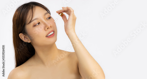 Skin care and beauty, young asian woman clean face skin dropping serum to treatment on white background.
