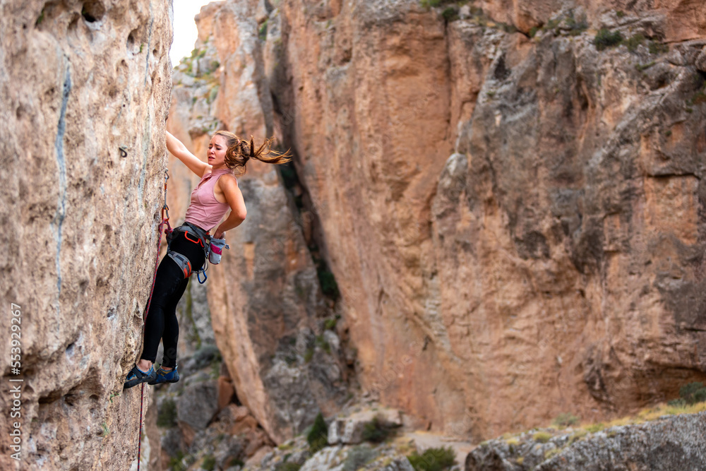 sport climbing. the girl overcomes the climbing route on the rock.