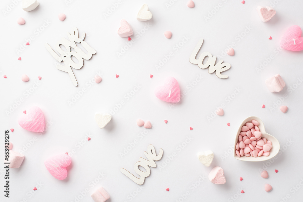 St Valentine's Day concept. Top view photo of inscriptions love heart shaped saucer with sprinkles marshmallow and pink candles on isolated white background