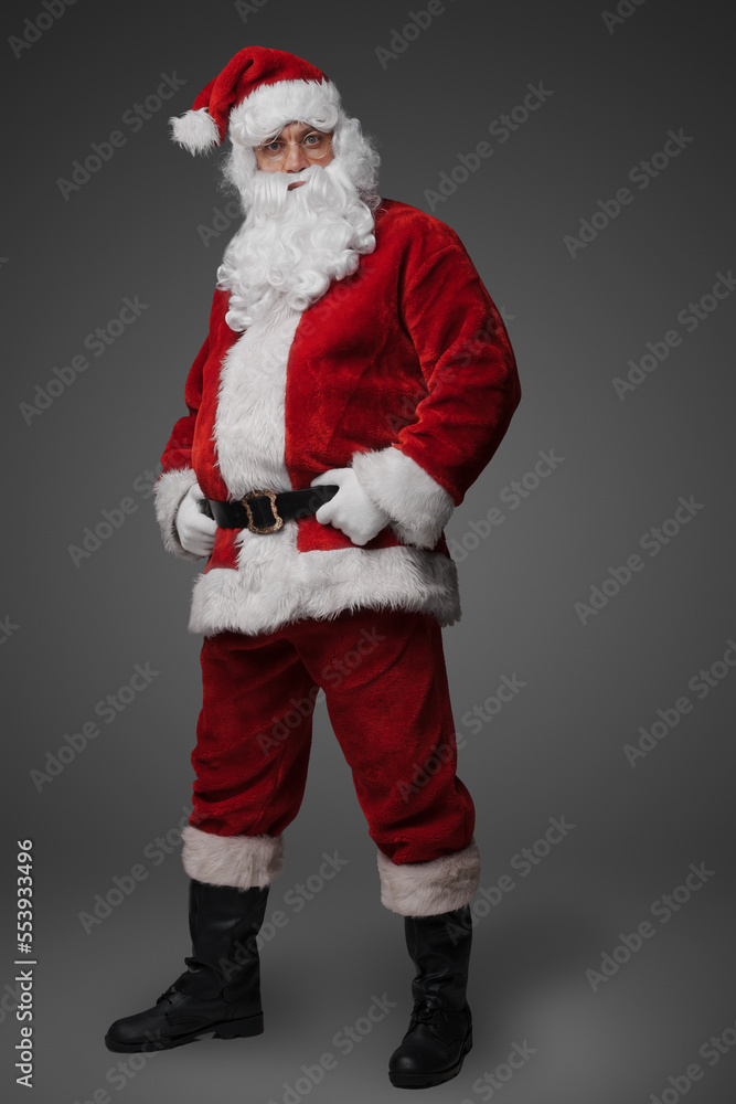 Studio shot of cheerful elderly santa dressed in red winter costume. Studio shot of cheerful elderly santa dressed in red winter costume.