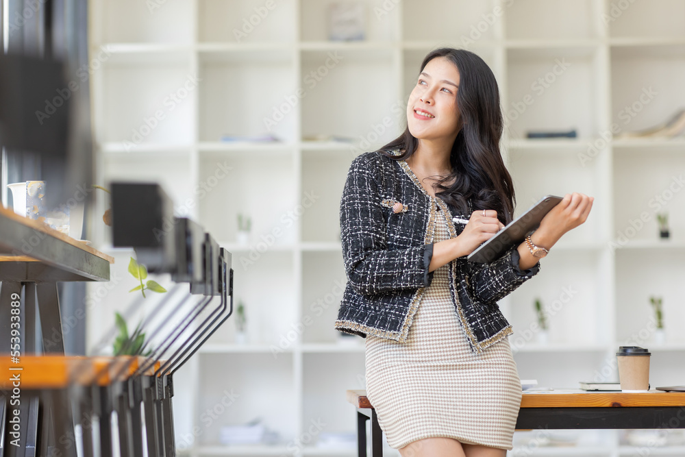 Asian Business woman using calculator and laptop for doing math finance on an office desk, tax, report, accounting, statistics, and analytical research concept Asian Business woman using calculator and laptop for doing math finance on an office desk, tax, report, accounting, statistics, and analytical research concept