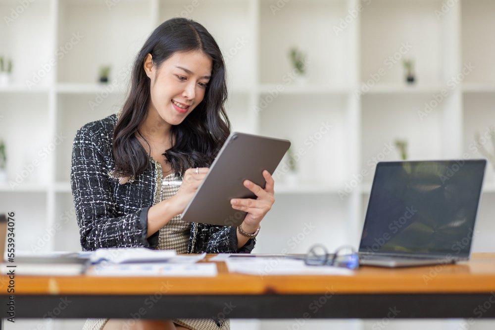 Asian Business woman using calculator and laptop for doing math finance on an office desk, tax, report, accounting, statistics, and analytical research concept Asian Business woman using calculator and laptop for doing math finance on an office desk, tax, report, accounting, statistics, and analytical research concept