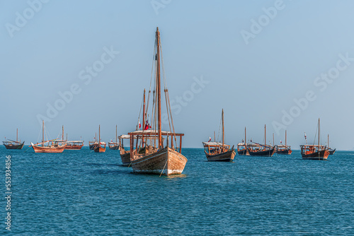 Dec 11th, 2022, Katara - Qatar: Traditional Qatari dhow wooden boats sailing in the Arabian gulf in Katara culture village beach.