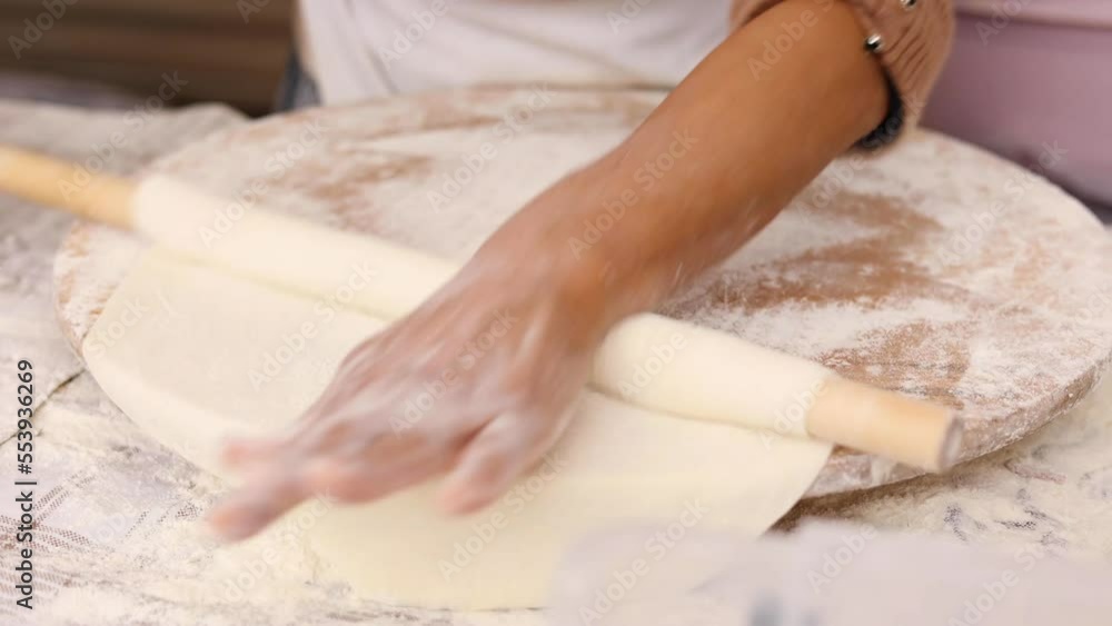 Woman rolls out dough, close up of woman's hands with rolling pin making Turkish traditional pancakes (gozleme) Woman rolls out dough, close up of woman's hands with rolling pin making Turkish traditional pancakes (gozleme)