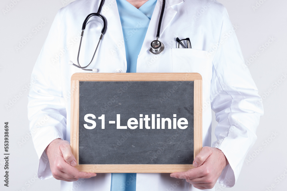 Arzt mit einer Tafel auf der S1-Leitlinie steht Arzt mit einer Tafel auf der S1-Leitlinie steht