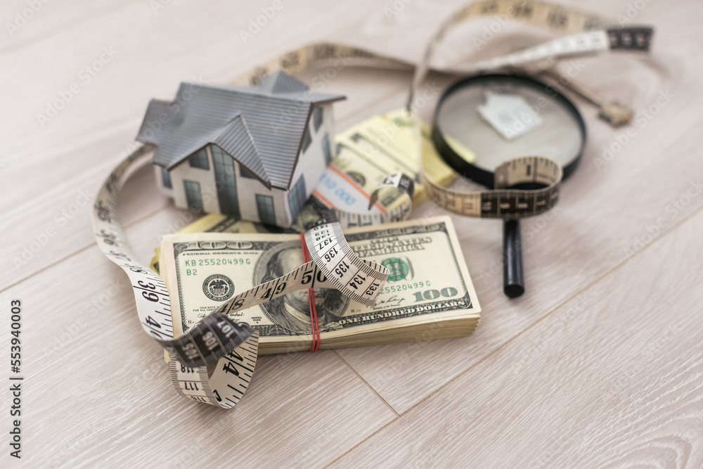 Model of house with magnifying glass and money on white. Model of house with magnifying glass and money on white.