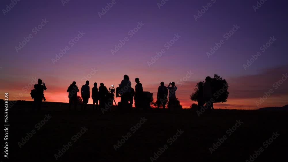 Fast speed silhouette of a movie crew at sunset on location land field Fast speed silhouette of a movie crew at sunset on location land field