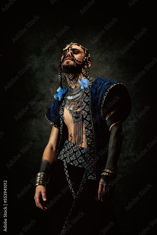 Tattooed bearded man, wearing ethnic clothing and jewelry Tattooed bearded man, wearing ethnic clothing and jewelry