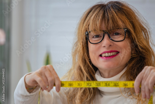 mature woman showing tape measure. diet and health concept