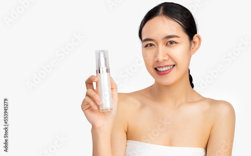 Young beautiful asian woman clean face skin holding bottle of serum product white background.