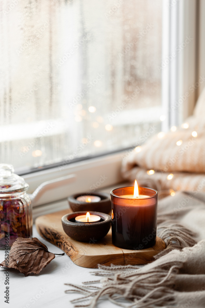 warm cozy window arrangement, winter or autumn concept, candles throw lights