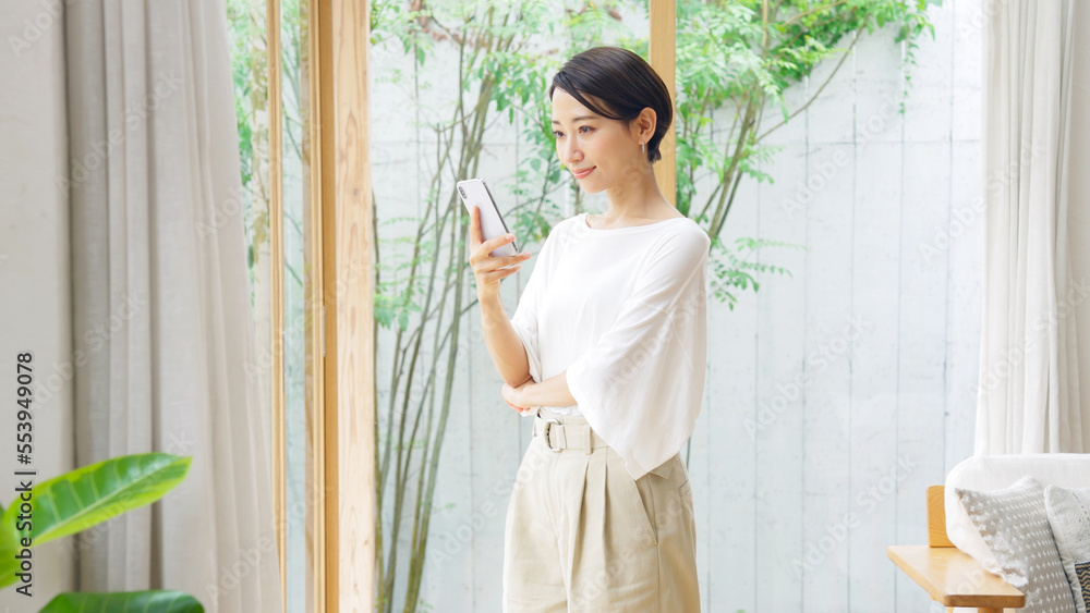 笑顔でスマホを見るミドル女性 笑顔でスマホを見るミドル女性