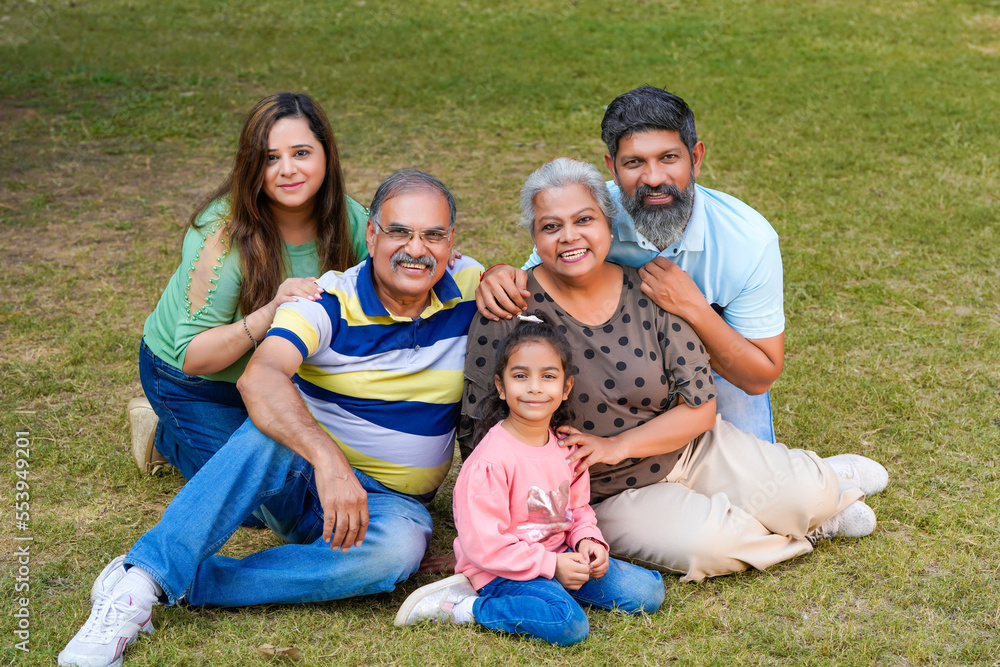 Happy indian or asian family sitting at park. Happy indian or asian family sitting at park.