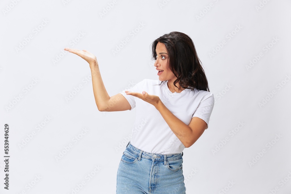 Woman smile and happiness shows a finger on the background, hand gestures, in a white t-shirt on a white background, copy space Woman smile and happiness shows a finger on the background, hand gestures, in a white t-shirt on a white background, copy space