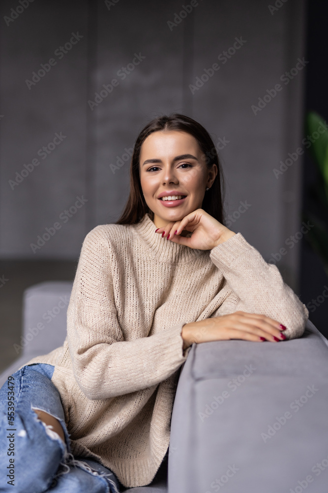 Attractive young woman sitting and dreaming on sofa at home Attractive young woman sitting and dreaming on sofa at home