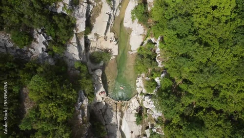 Cinematic Holiday destination in Greece. Dammed river in the mountains forms a pool. People swimming in nature. photo