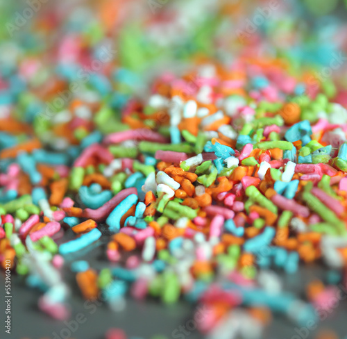 Close up of multiple colorful sweet sprinkles over blurred background created using Generative AI technology