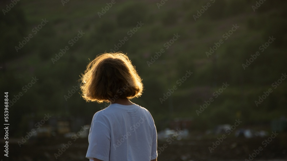 a girl with short hair looks into the distance on a sunny polar day