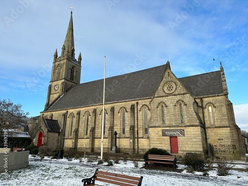 Old stone church with snow on the ground and a blue sky background. Taken in Ramsbottom Lancashire England. 