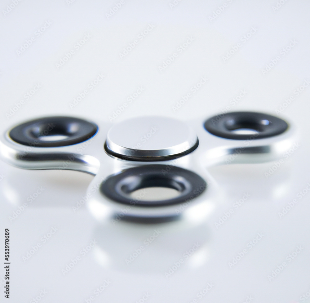 Image of close up of metallic fidget spinner on white background created using Generative AI technology Image of close up of metallic fidget spinner on white background created using Generative AI technology