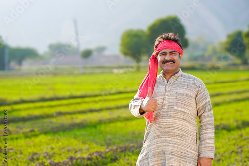 Canvastavla Happy Indian farmer standing at agriculture field and showing thumps up