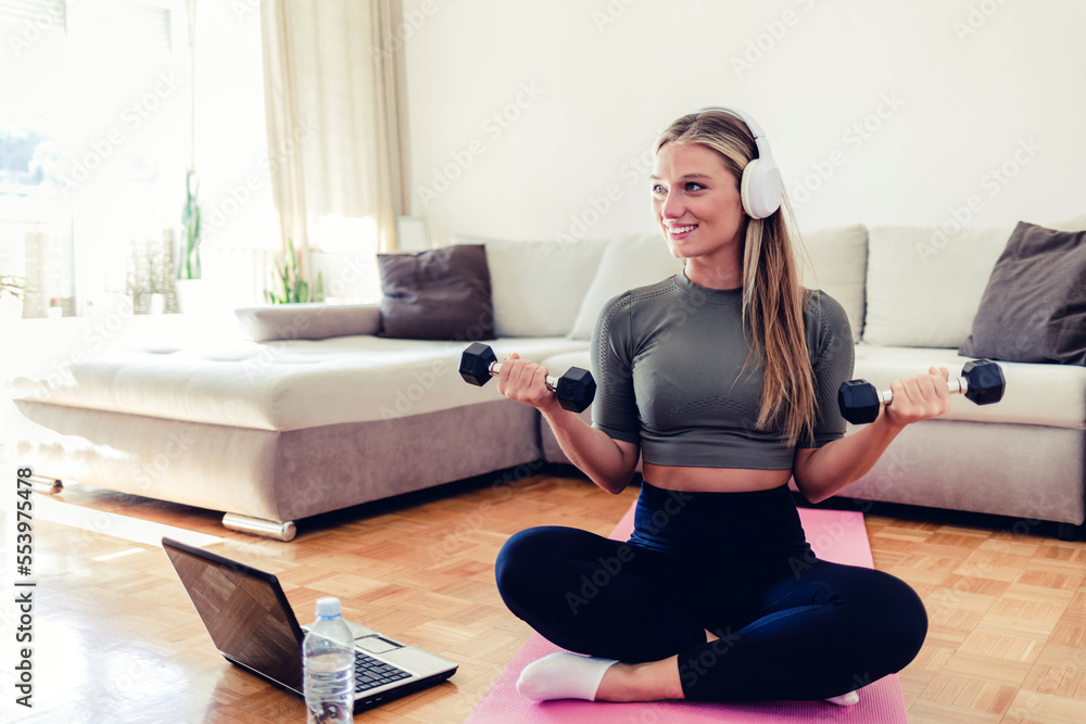 Fitness, workout, healthy living and diet concept. Young woman doing gymnastic exercises at home. Determined woman losing weight at home and exercising with dumbbells Fitness, workout, healthy living and diet concept. Young woman doing gymnastic exercises at home. Determined woman losing weight at home and exercising with dumbbells