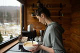 a young woman prepares delicious pancakes in the kitchen