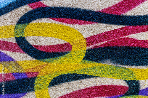colorful background of graffiti in a city with bright aerosol strips and beautiful colors , urban school wall backdrop