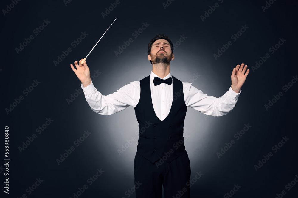 Professional conductor with baton on dark background Professional conductor with baton on dark background