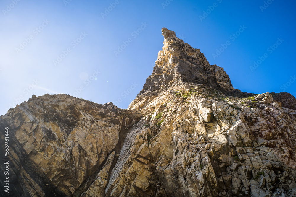 Fototapeta premium Cliffs, sharp spectacular rocks rising from the ocean. waves. Ursa sandy beach under the cliff. Sunny day. Horizontally