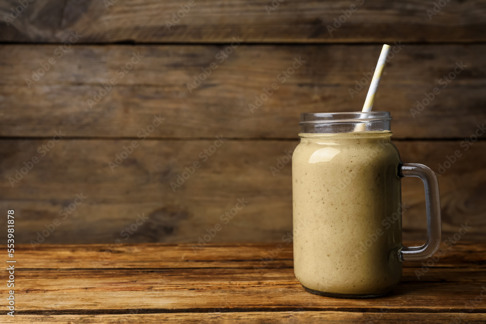 Mason jar with delicious fruit smoothie on wooden table. Space for text Mason jar with delicious fruit smoothie on wooden table. Space for text