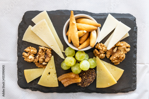 Overhead view on platter of cheese, cracker, nuts and grapes served on cheeseboard photo