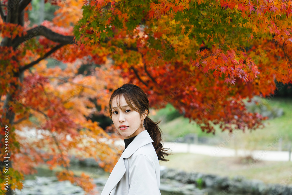 紅葉した日本庭園を観光する女性 紅葉した日本庭園を観光する女性
