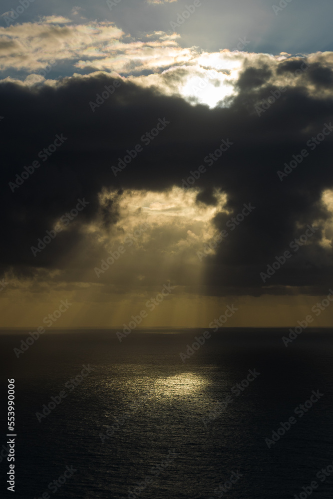 beautiful sunset over sea with sun rays between black clouds beautiful sunset over sea with sun rays between black clouds