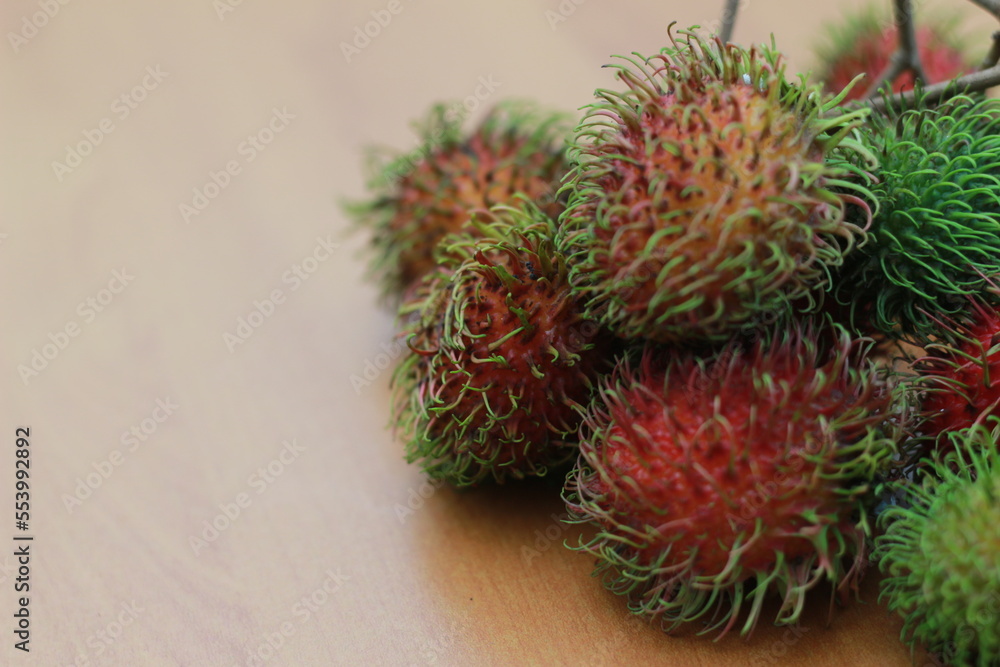 rambutan fruit which is reddish green in color having sweet taste isolated on table. Food concept photo. rambutan fruit which is reddish green in color having sweet taste isolated on table. Food concept photo.