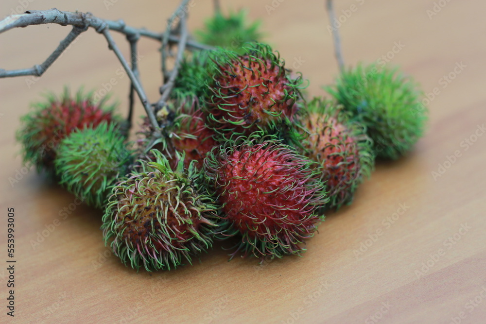 rambutan fruit which is reddish green in color having sweet taste isolated on table. Food concept photo. rambutan fruit which is reddish green in color having sweet taste isolated on table. Food concept photo.