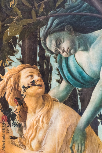 Close-up on old painting showing mythological scene in which a male wind god interacts with a blond young girl with flowers in her mouth