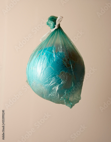 Earth globe in plastic bag. Climate change  enviromental pollution concept.