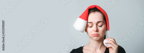 Fotografia Portrait of beautiful woman with closed eyes in Santa Claus hat