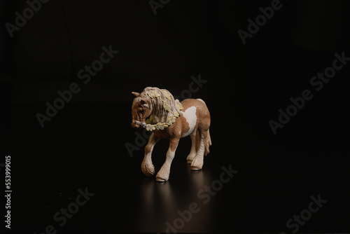 Black toy horse isolated on black background