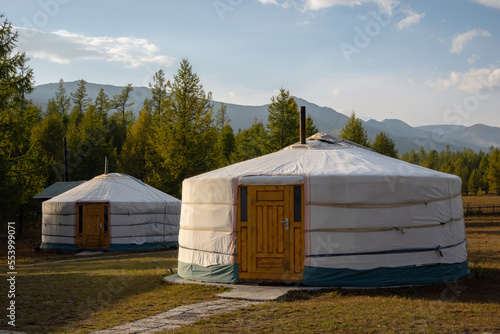 Yurt camp on a beautiful sunny day in Mongolia. Ger campsite in rural country, nature in the background. © CrispyMedia