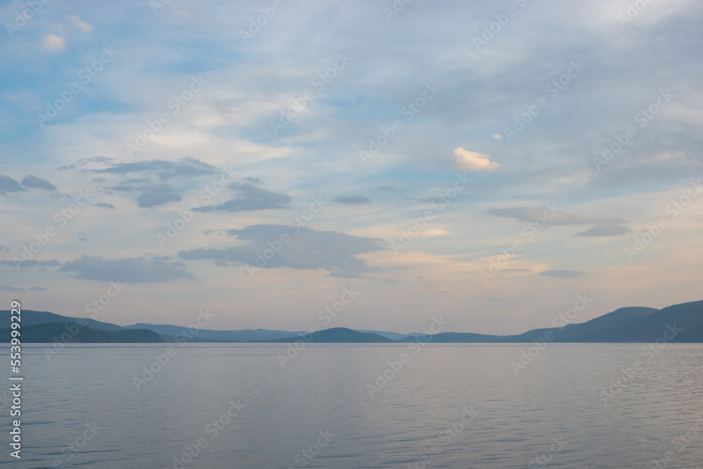 Majestic view of lake Khövsgöl, beautiful mountains in the background. Water coast with the misty looking sky with the clouds in horizon.