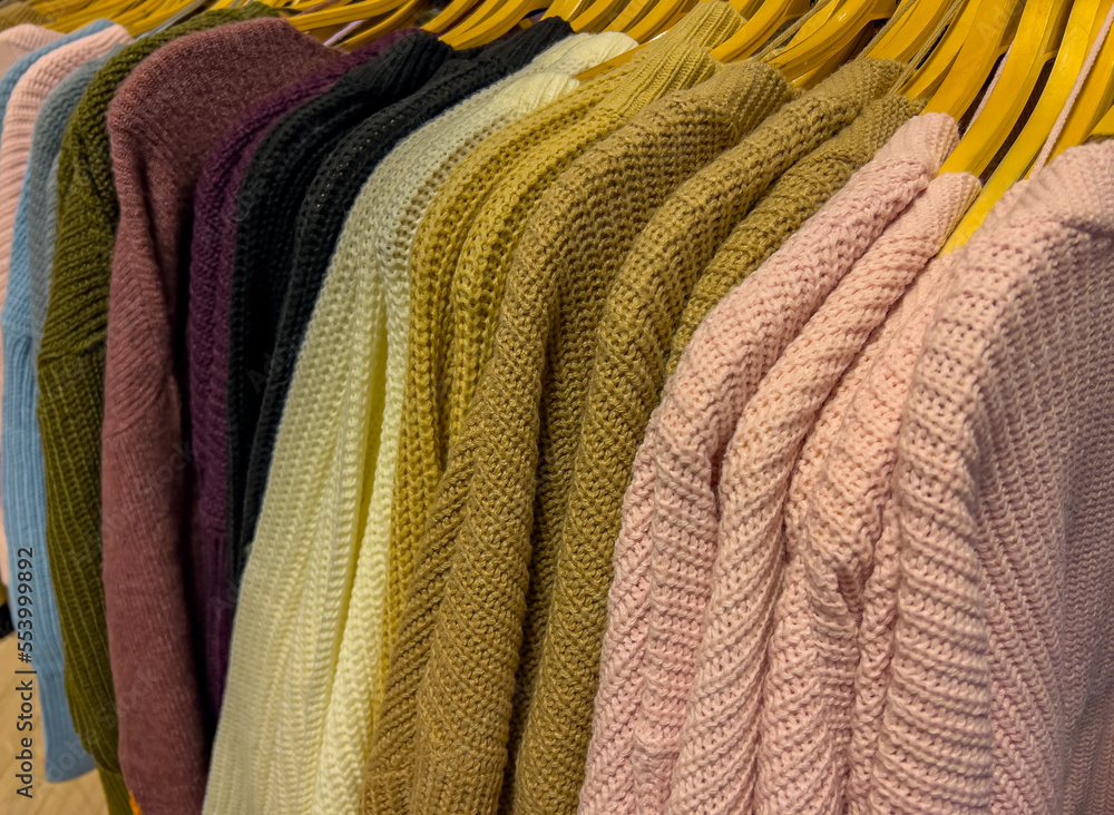Strickjacke und Strick Pullover auf Kleiderbügel zum Winterschlussverkauf  Stock-Foto | Adobe Stock